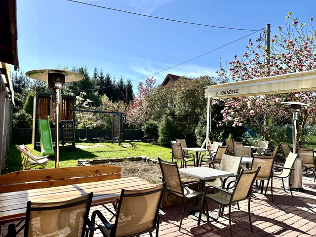 Zadaszony ogródek restauracji ze stolikami pod parasolem